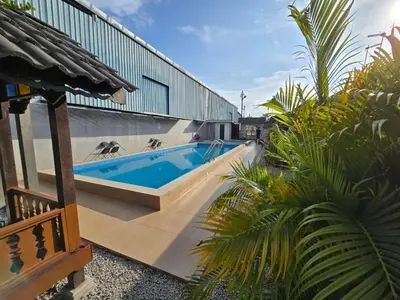a swimming pool in front of a building at Homestay Tok Ani by Ardzman Hospitality in Permatang Pauh