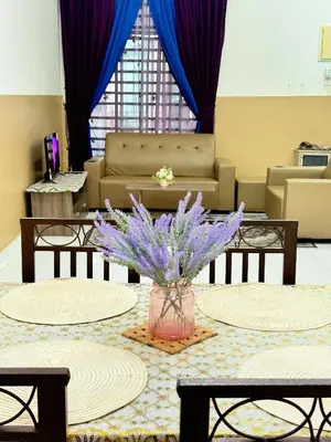 a lobby with a table with purple flowers in a vase at Seri Pinggiran HOMESTAY Bertam Perdana in Kepala Batas
