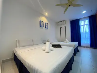 a bedroom with two beds with white sheets and a ceiling at Mak Sa'adiah Hotel in Kampung Teluk Nipah