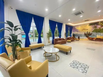 a lobby with couches and chairs and a table at Mak Sa'adiah Hotel in Kampung Teluk Nipah