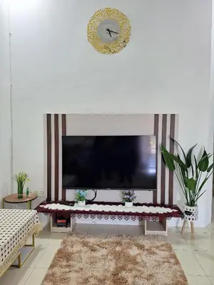 a living room with a large flat screen tv at Rosselle Homestay, Sabak Bernam in Sabak Bernam