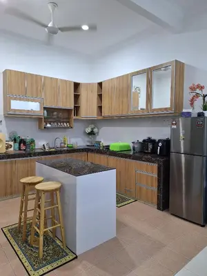 a kitchen with wooden cabinets and a stainless steel refrigerator at Rosselle Homestay, Sabak Bernam in Sabak Bernam