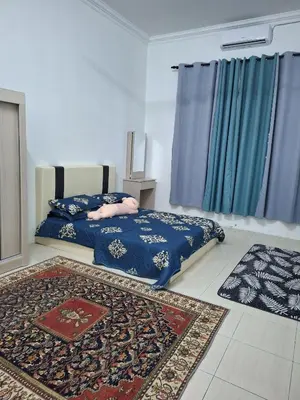 a bedroom with a bed with blue sheets and a rug at Rosselle Homestay, Sabak Bernam in Sabak Bernam