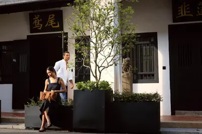 a man and a woman sitting inront of a building at Soori Penang in George Town