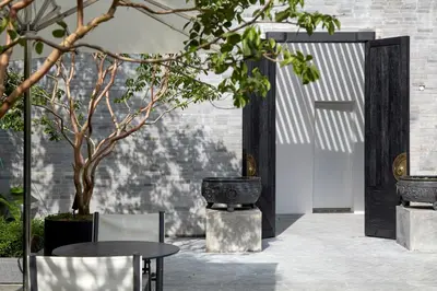 a patio with a door and a table and trees at Soori Penang in George Town