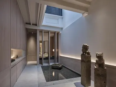 a hallway of a house with a statue in the middle at Soori Penang in George Town