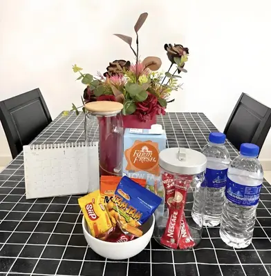 a table with food and water bottles on it at J Cozy Stay - 3B 2B, Fair Park Ipoh in Ipoh