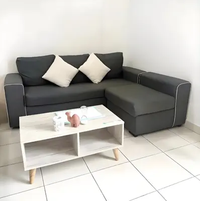 a living room with a black couch and a coffee table at J Cozy Stay - 3B 2B, Fair Park Ipoh in Ipoh