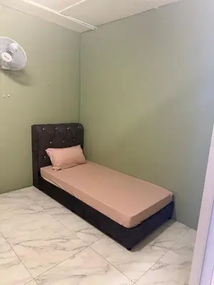 a bed in a corner of a room at Rina Hostel in Ipoh
