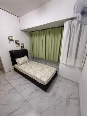 a bedroom with a bed and a window with green curtains at Rina Hostel in Ipoh