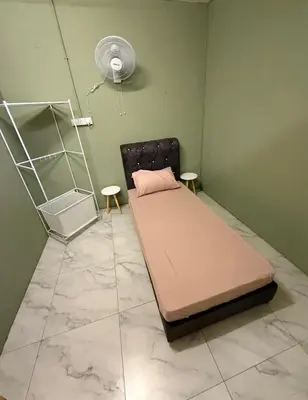 a hospital room with a bed and a fan at Rina Hostel in Ipoh