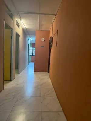 an empty hallway with a clock on the wall at Rina Hostel in Ipoh