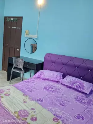 a purple bed with a purple headboard and a desk at Shaja Homestay in Kampong Kepayang