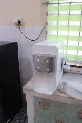 a white coffee maker on a counter in a bathroom at Shaja Homestay in Kampong Kepayang