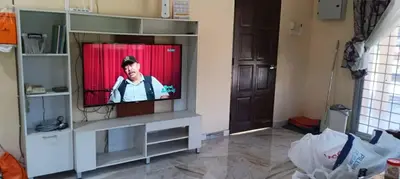 a living room with a television in a entertainment center at Shaja Homestay in Kampong Kepayang