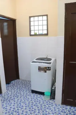 a small refrigerator in a room with a window at Shaja Homestay in Kampong Kepayang