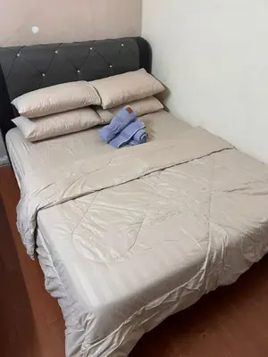 a unmade bed with a blue shirt on it at laman terrace in Sungai Petani