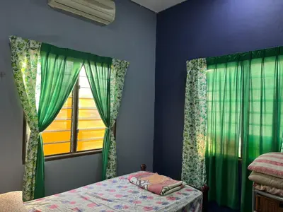 a bedroom with a bed and a window at Homestay ABAH in Nibung Tebal