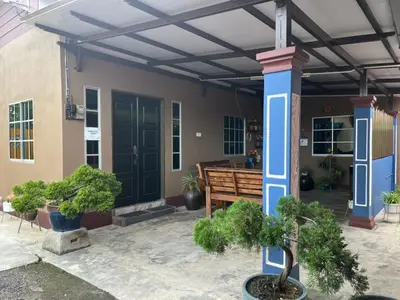 a house with a blue front porch with potted plants at Homestay ABAH in Nibung Tebal