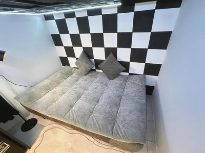 a bed in a room with a checkered wall at Unisuites Kampar Studio UTAR TARC -3pax, Pet Friendly, FREE 1 Carpark & Netflix in Kampar