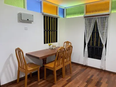 a dining room with a wooden table and chairs at Rumah Inap Kampung Agong Sunrise in Penaga