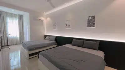 a bedroom with two beds in a room at Alle House by Wei in Kampong Gurun