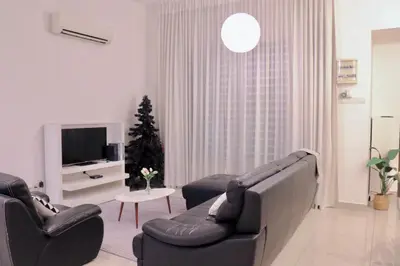 a living room with two couches and a christmas tree at Alle House by Wei in Kampong Gurun