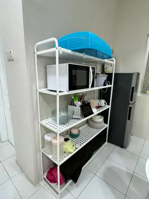 a kitchen shelf with a microwave and some dishes at Ayaan Quintet Evergreen with FIFA & Private Parking in Tanah Rata