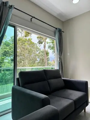 a living room with a couch and a large window at Ayaan Quintet Evergreen with FIFA & Private Parking in Tanah Rata