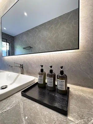 two bottles of soap sitting on a tray next to a sink at Tambuna Retreat ,TAMBUN ,IPOH in Tambun