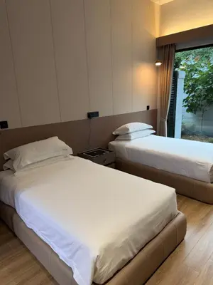 two beds in a hotel room with a window at Tambuna Retreat ,TAMBUN ,IPOH in Tambun