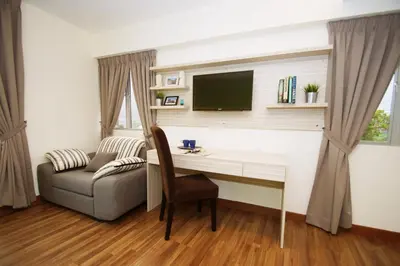 a living room with a desk and a couch and a television at Good Luck Inn in Ayer Itam