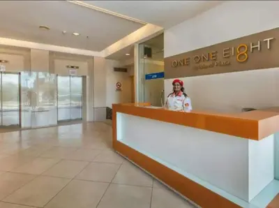 a woman standing at a one eighty eight counter at Modern Cozy Seaview Entire Suites 118 Island Plaza in George Town