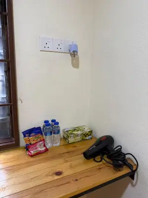 a counter with bottles of water and a phone on it at MR B hotel in Bukit Mertajam
