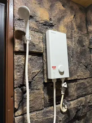 a light on a stone wall with a plug and cables at MR B hotel in Bukit Mertajam