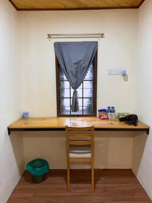 a desk with a chair in a room with a window at MR B hotel in Bukit Mertajam