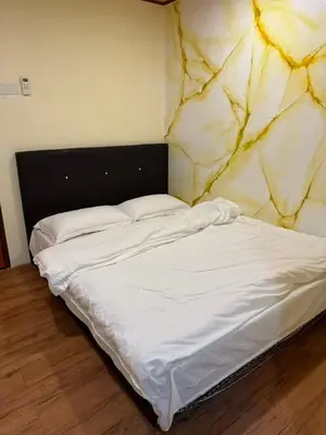 an unmade bed in a room with a stone wall at MR B hotel in Bukit Mertajam