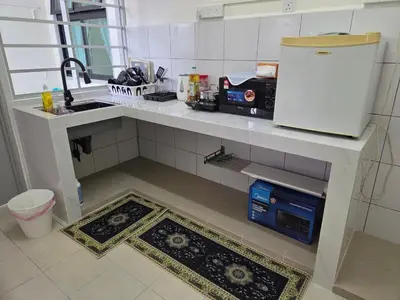 a kitchen with a counter top with a refrigerator at QaiDaff Homestay CH in Cameron Highlands