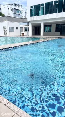 a swimming pool with blue water in front of a building at RR Casa Space Homestay Ipoh in Ipoh