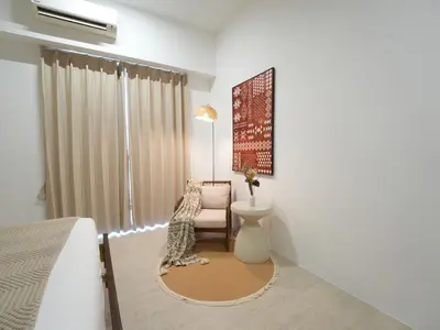 a bedroom with a bed and a chair and a window at Cozy Seaview Escape 2BR 6pax bythesea bathroom in Pulau Pinang
