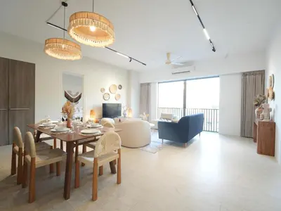 a dining room and living room with a table and chairs at Cozy Seaview Escape 2BR 6pax bythesea bathroom in Pulau Pinang