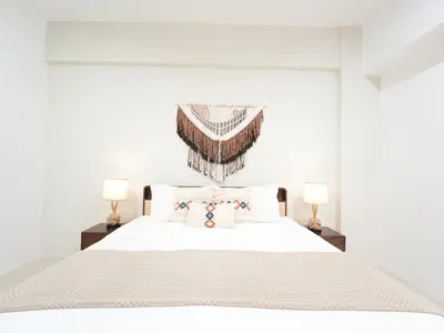a white bedroom with a white bed with two lamps at Cozy Seaview Escape 2BR 6pax bythesea bathroom in Pulau Pinang