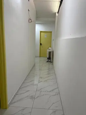 a hallway with a yellow door and a white wall at Rest N Go CM in Ipoh