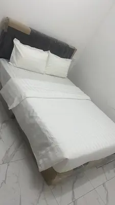 a bed with white sheets and pillows on it at Rest N Go CM in Ipoh