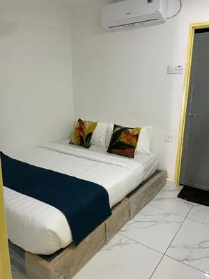 a bed in a room with white walls at Rest N Go CM in Ipoh