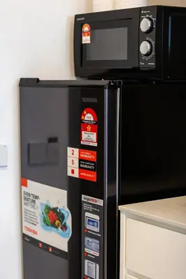 a microwave oven sitting on top of a refrigerator at M22 #CityView SeaView #Georgetown #35 in George Town