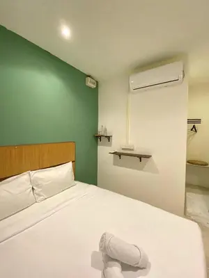 a bedroom with a white bed and a green wall at Sembilan Inn by Soft Loft in George Town
