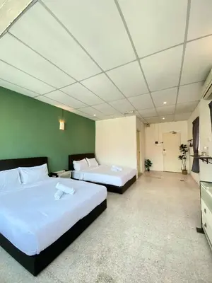 two beds in a hotel room with green walls at Sembilan Inn by Soft Loft in George Town