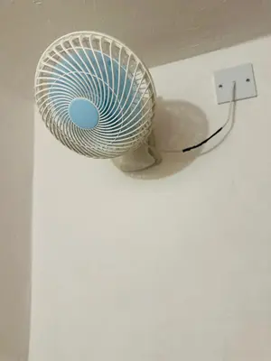 a white fan is plugged into a lightswitch at The Century Hostel George Town \u4e54\u6cbb\u5e02\u4e16\u7eaa\u9752\u65c5 in George Town