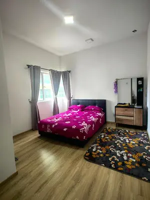 a bedroom with a pink bed and a rug at KAZ homestay in Tanah Rata